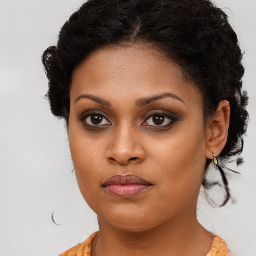 Joyful black young-adult female with long  brown hair and brown eyes