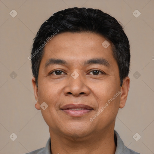 Joyful latino adult male with short  black hair and brown eyes