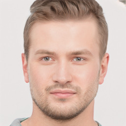 Joyful white young-adult male with short  brown hair and grey eyes