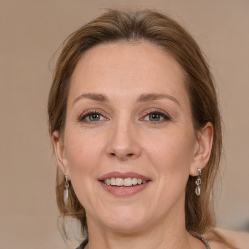 Joyful white adult female with medium  brown hair and grey eyes