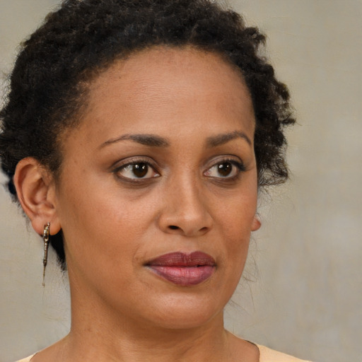 Joyful black young-adult female with short  brown hair and brown eyes
