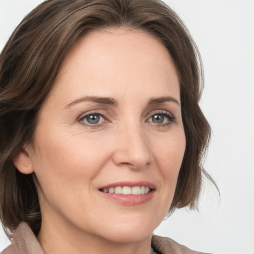 Joyful white adult female with medium  brown hair and grey eyes