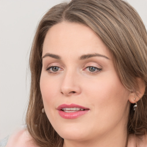 Joyful white young-adult female with long  brown hair and grey eyes