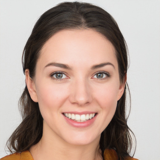 Joyful white young-adult female with long  brown hair and blue eyes