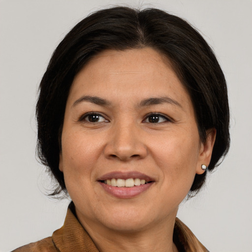 Joyful latino adult female with medium  brown hair and brown eyes