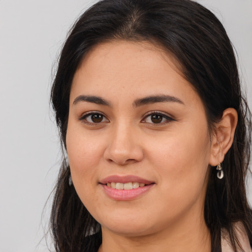 Joyful latino young-adult female with long  brown hair and brown eyes