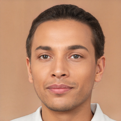 Joyful latino young-adult male with short  black hair and brown eyes