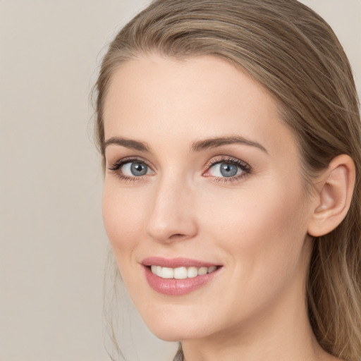 Joyful white young-adult female with long  brown hair and grey eyes