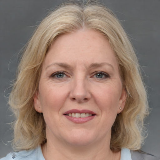 Joyful white adult female with medium  brown hair and grey eyes