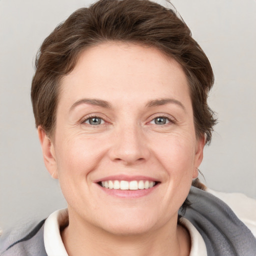 Joyful white adult female with short  brown hair and grey eyes