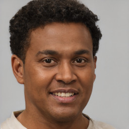 Joyful latino young-adult male with short  brown hair and brown eyes