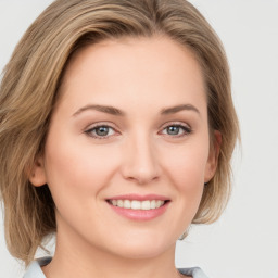 Joyful white young-adult female with medium  brown hair and green eyes