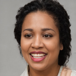 Joyful black young-adult female with long  brown hair and brown eyes