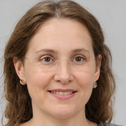 Joyful white adult female with medium  brown hair and grey eyes