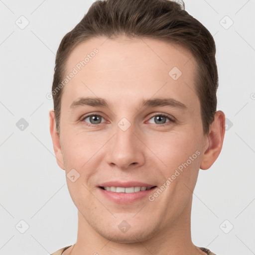 Joyful white young-adult male with short  brown hair and grey eyes