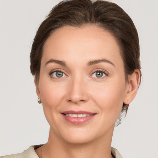 Joyful white young-adult female with medium  brown hair and grey eyes