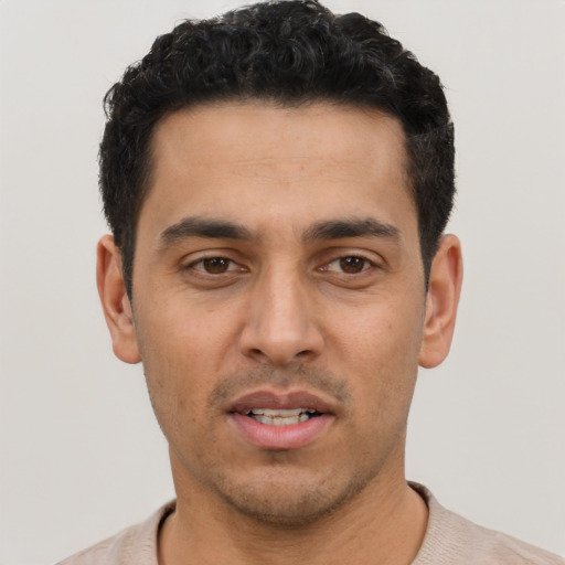 Joyful latino young-adult male with short  black hair and brown eyes