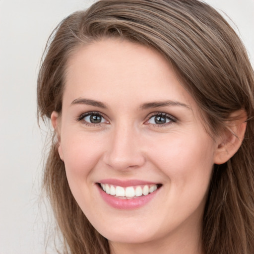 Joyful white young-adult female with long  brown hair and grey eyes