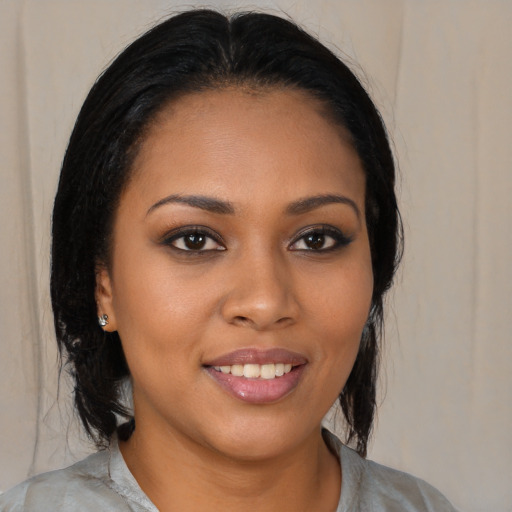 Joyful black young-adult female with medium  brown hair and brown eyes