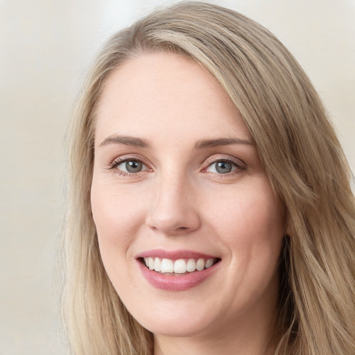 Joyful white young-adult female with long  brown hair and blue eyes