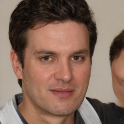 Joyful white adult male with short  brown hair and brown eyes