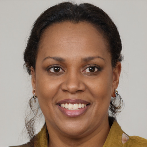 Joyful black adult female with medium  brown hair and brown eyes
