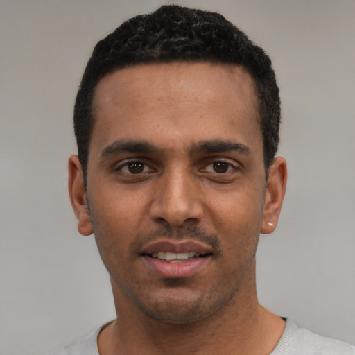 Joyful white young-adult male with short  black hair and brown eyes