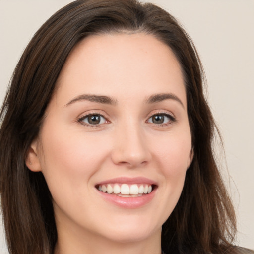 Joyful white young-adult female with long  brown hair and brown eyes