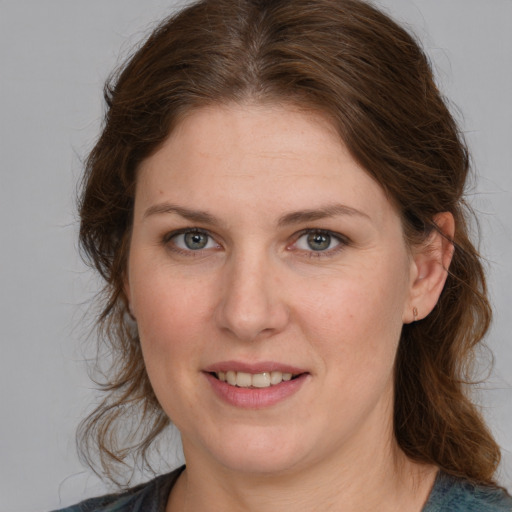 Joyful white young-adult female with medium  brown hair and blue eyes