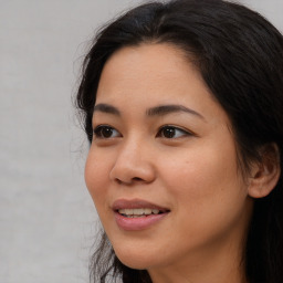 Joyful asian young-adult female with long  brown hair and brown eyes