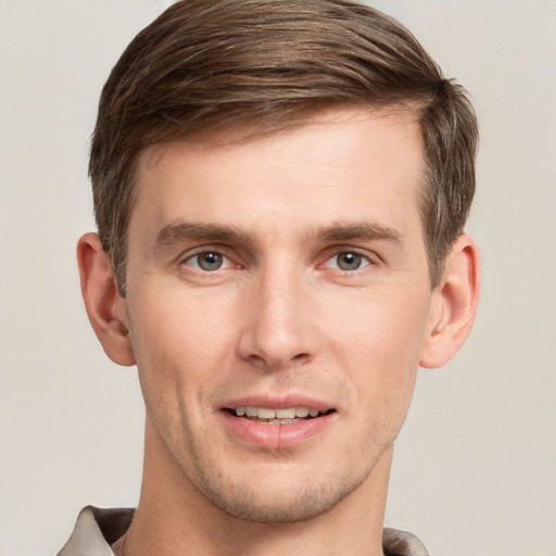 Joyful white young-adult male with short  brown hair and grey eyes