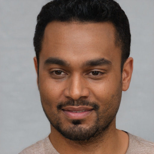 Joyful black young-adult male with short  black hair and brown eyes