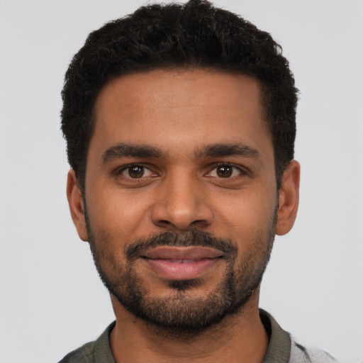 Joyful black young-adult male with short  black hair and brown eyes