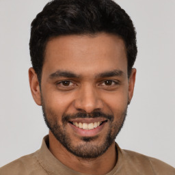 Joyful latino young-adult male with short  black hair and brown eyes