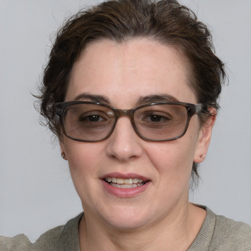 Joyful white adult female with short  brown hair and blue eyes