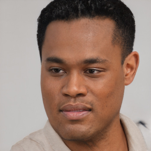 Joyful black young-adult male with short  black hair and brown eyes