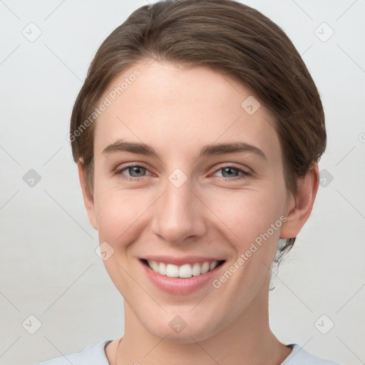 Joyful white young-adult female with short  brown hair and grey eyes