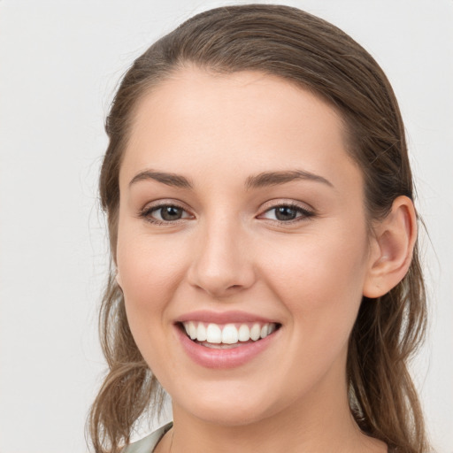 Joyful white young-adult female with long  brown hair and grey eyes