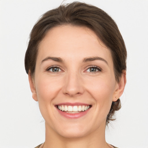 Joyful white young-adult female with medium  brown hair and grey eyes