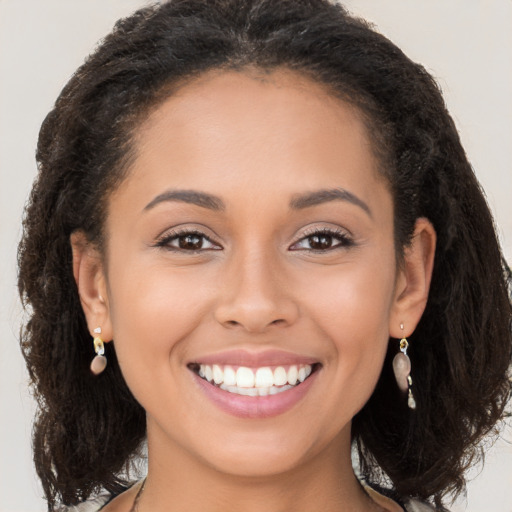 Joyful latino young-adult female with long  brown hair and brown eyes