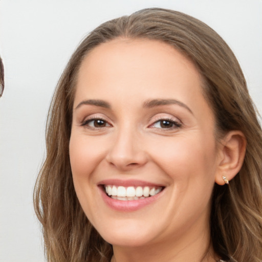 Joyful white young-adult female with long  brown hair and blue eyes