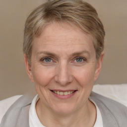 Joyful white adult female with short  brown hair and blue eyes