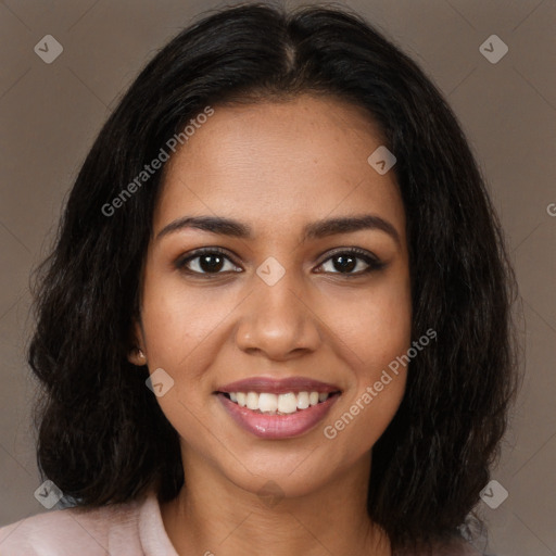 Joyful black young-adult female with long  brown hair and brown eyes