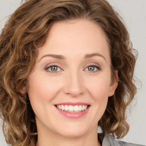 Joyful white young-adult female with medium  brown hair and green eyes