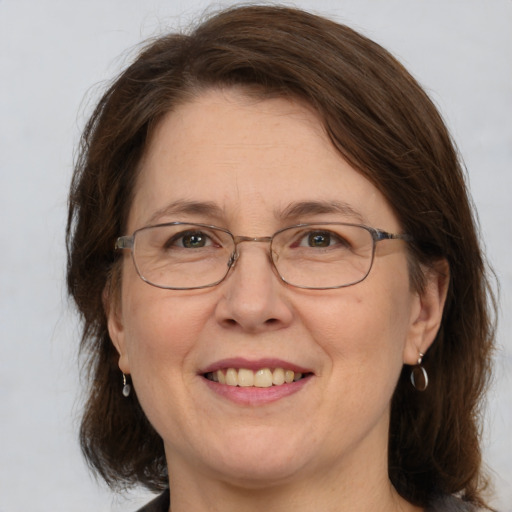 Joyful white adult female with medium  brown hair and grey eyes