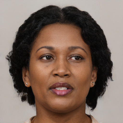 Joyful black adult female with long  brown hair and brown eyes