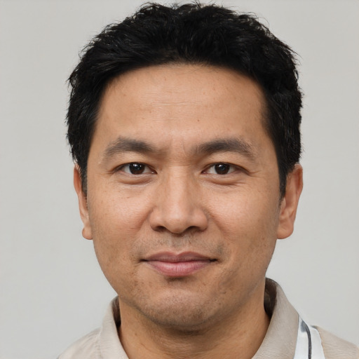 Joyful asian adult male with short  black hair and brown eyes
