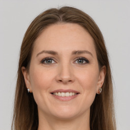 Joyful white young-adult female with long  brown hair and grey eyes