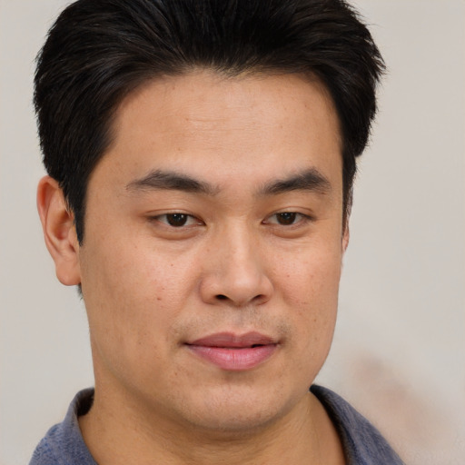 Joyful asian young-adult male with short  brown hair and brown eyes