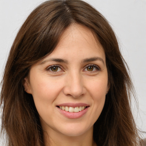 Joyful white young-adult female with long  brown hair and brown eyes